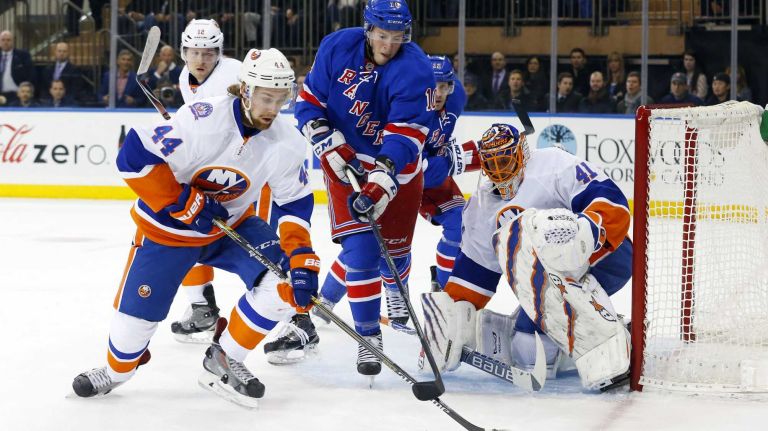 Calvin de Haan #44 and Jaroslav Halak #41 of the New York Islanders defend the net in the first period against J.T. Miller #10 of the New York Rangers at Madison Square Garden on Tuesday, Jan. 13, 2015.