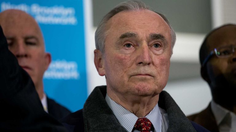 NYPD Commissioner William Bratton listens as New York Mayor Bill de Blasio speaks during a quiet, but emotional, news conference at Woodhull Medical Center in Brooklyn on Saturday, Dec. 20, 2014, in the wake of a fatal shooting of two NYPD officers.