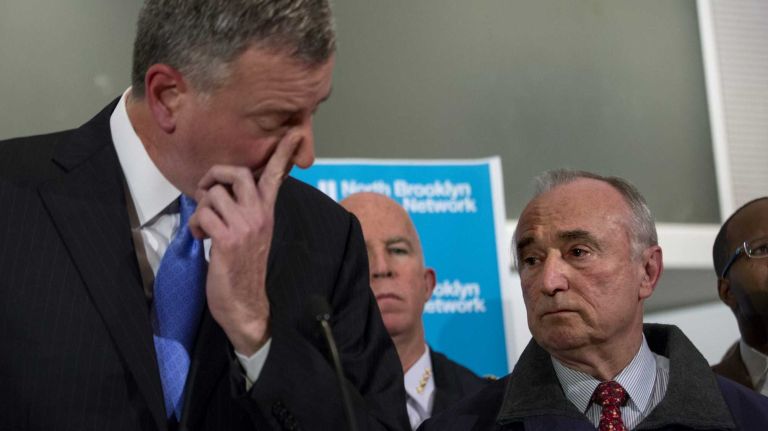 New York Mayor Bill de Blasio speaks as NYPD Commissioner William Bratton listens during a news conference at Woodhull Medical Center in Brooklyn on Saturday, Dec. 20, 2014, in the wake of a fatal shooting of two NYPD officers.