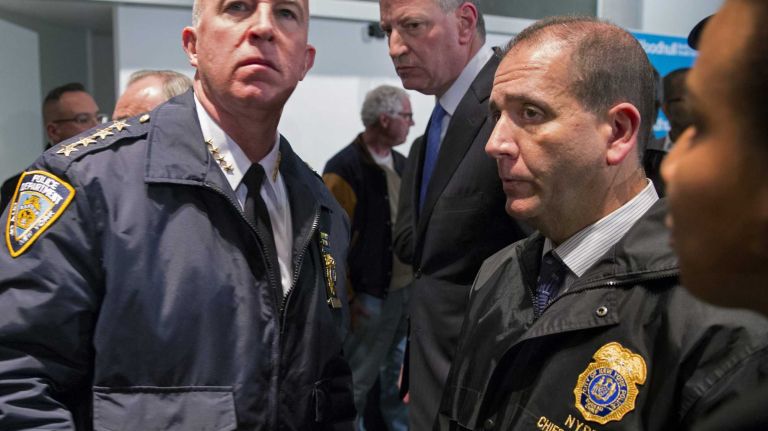 New York Mayor Bill de Blasio leaves a news conference at Woodhull Medical Center in Brooklyn on Saturday, Dec. 20, 2014, in the wake of a shooting of two NYPD officers as they sat in their car at a nearby intersection. At left is NYPD Chief of Department James O'Neill, and at right is Chief of Patrol Carlos Gomez.