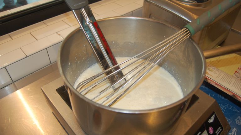 Clip a candy thermometer to the saucepan and set the pan over medium heat. Cook, stirring often with a rubber spatula and scraping the bottom of the pan to prevent sticking and burning, until the mixture reaches 110ºF, 5 to 10 minutes. Remove the pan from the heat.