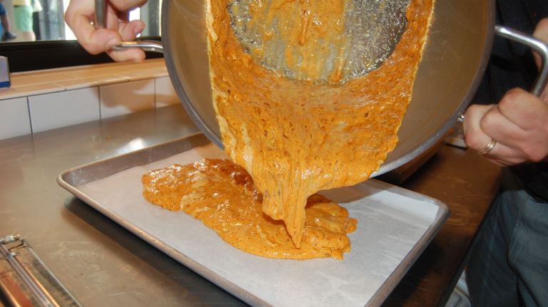 When the honeycomb stops growing up the sides of the pot, gently pour it onto the prepared baking sheet. Let it cool. Refrigerate the candy for 30 minutes.