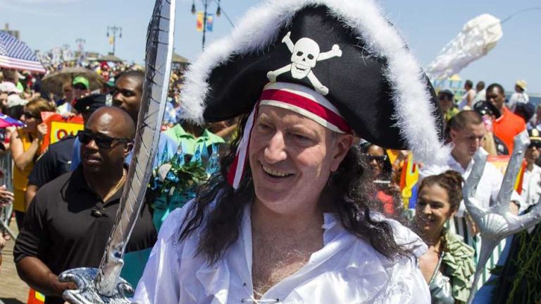 New York City Mayor Bill de Blasio greets a crowd on the boardwalk as he marches in the annual Coney Island Mermaid Parade on Saturday, June 21, 2014.