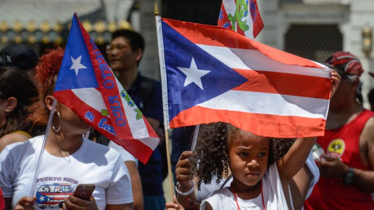 A young spectator holds up a flag during the Puerto Rican Day Parade on Sunday, June 11, 2017. 
