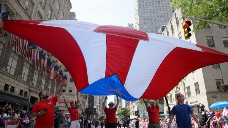 Participants wave an oversized Puerto Rican flag during the 60th annual Puerto Rican Day Parade in Manhattan on Sunday, June 11, 2017. 