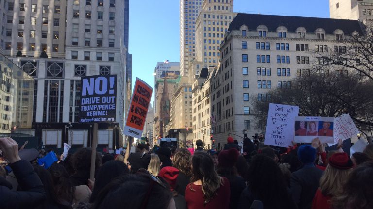 People hold up signs at the A Day Without a Woman rally held near 59th Street and Fifth Avenue in Manhattan on Wednesday, March 8, 2017. 