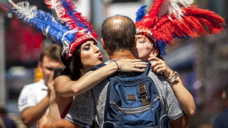 Topless performers pose for pictures with tourists in Times Square, Manhattan, on Aug.  18, 2015. The city is looking for ways to legally rein in the behavior of topless women, cartoon mascots, beggars and others who are hustling tourists and passersby for cash in Times Square.