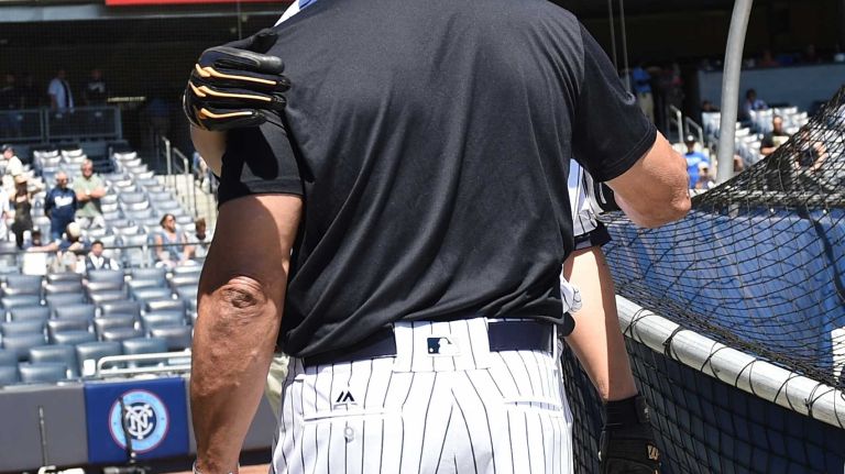 Former New York Yankees players Hideki Matsui and Reggie Jackson embrace during the 70th annual Old-Timers' Day at Yankee Stadium on Sunday, June 12, 2016.