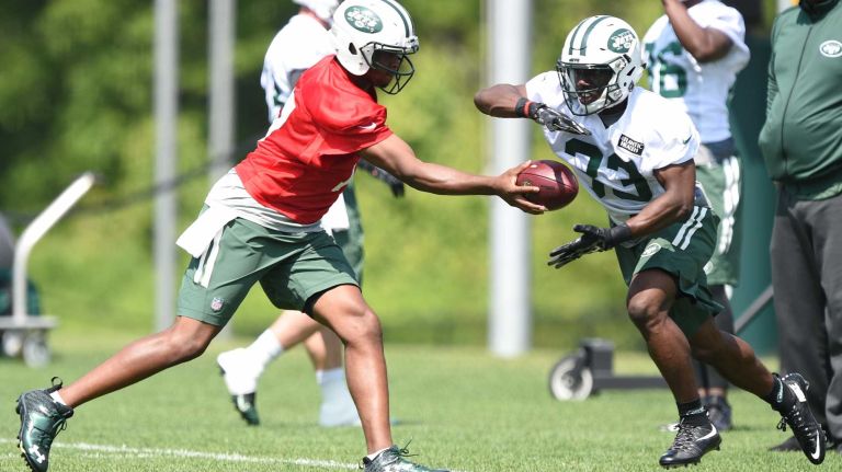 New York Jets quarterback Geno Smith hands the football off to Jets running back Romar Morris during Organized Team Activities at the Jets Training Center on Wednesday, May 25, 2016.