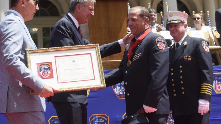 FDNY firefighter Michael J. Shepherd, of Brooklyn, shakes hands with New York City Mayor Bill de Blasio after receiving the Chief John J. McElligot Medal/FFs Fitzpatrick and Frisby Award at the FDNY Medal Day Ceremony in front of City Hall in Manhattan on Wednesday, June 01, 2016. Firefighter Shepherd, while off duty, ascended a fire escape and assisted a woman to the street following a gas explosion in her Manhattan building.