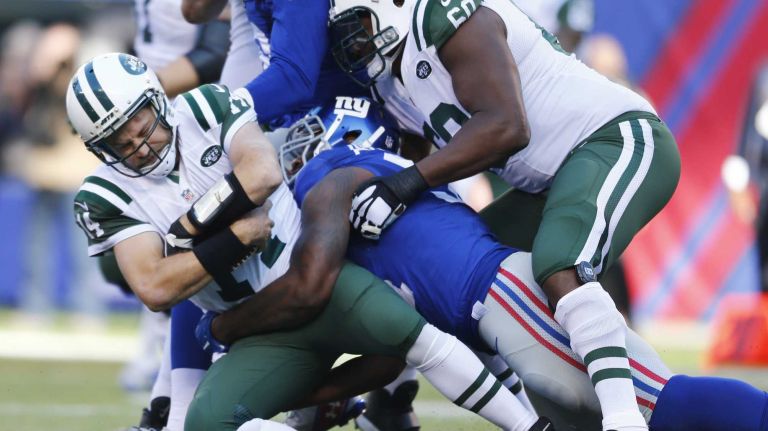 Ryan Fitzpatrick #14 of the New York Jets is sacked by Robert Ayers #91 of the New York Giants at MetLife Stadium on Sunday, Dec. 6, 2015 in East Rutherford, N.J.