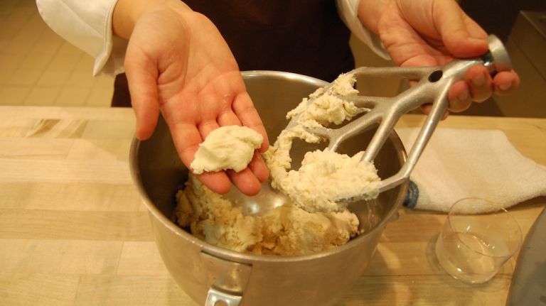 After adding water, the dough should look like this. You should be able to squeeze the pieces off the paddle and they come together. If not, add a tiny bit more water. 
