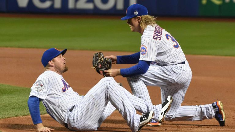 New York Mets starting pitcher Noah Syndergaard and New York Mets first baseman Lucas Duda collide on a ball hit by Kansas City Royals third baseman Mike Moustakas (8) in first inning during Game 3 of the World Series at Citi Field on Friday, Oct. 30, 2015.