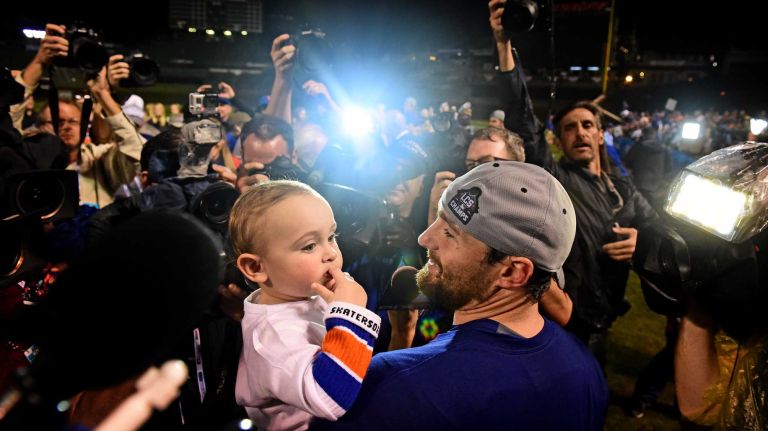 New York Mets Daniel Murphy with his son Noah as he celebrates his victory in Game 4 of the NLCS against the Chicago Cubs at Wrigley Field on Wednesday, Oct. 21, 2015.