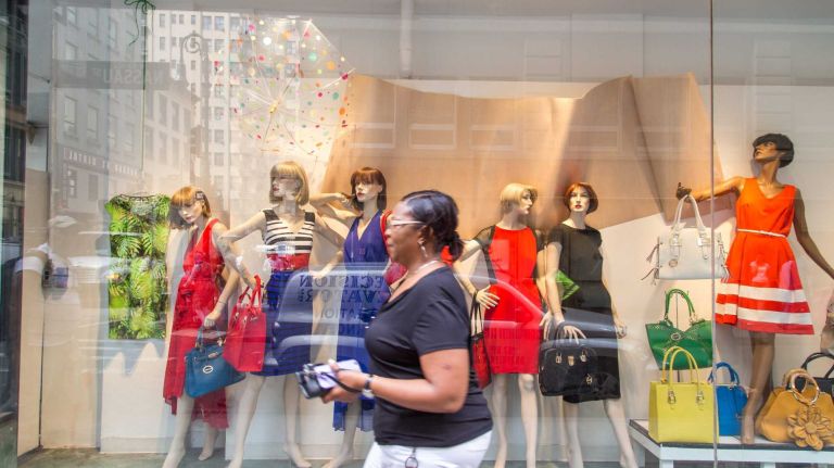 Shoppers pass by the storefront of boutique Designer Promise in Manhattan's Financial District on Aug. 20, 2015.