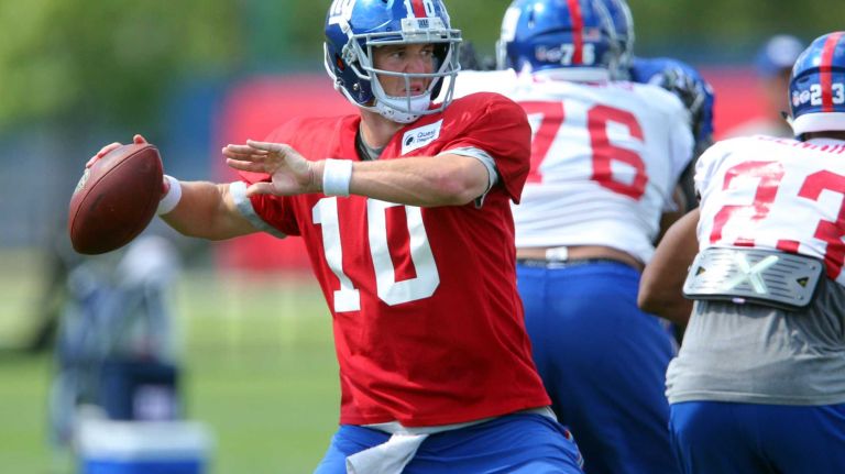 New York Giants quarterback Eli Manning #10 drops back to pass during training camp at the Quest Diagnostics Training Center in East Rutherford, N.J., on Sunday, Aug. 2, 2015.