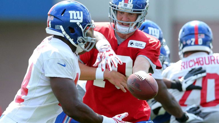 New York Giants quarterback Eli Manning hands off to running back Andre Williams during training camp at the Quest Diagnostics Training Center in East Rutherford, N.J., on Saturday, Aug. 1, 2015.