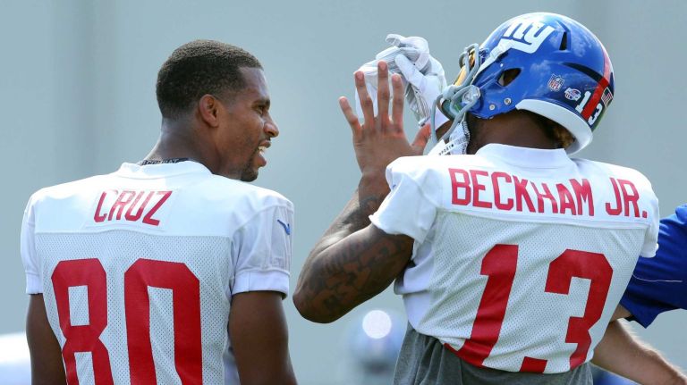 New York Giants wide receiver Odell Beckham Jr. shows wide receiver Victor Cruz where he jammed fingers on his left hand while trying to make a catch during training camp at the Quest Diagnostics Training Center in East Rutherford, N.J., on Saturday, Aug. 1, 2015.