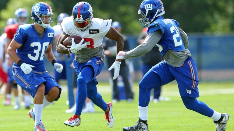 New York Giants wide receiver Odell Beckham Jr. runs the ball between safety Cooper Taylor and cornerback Prince Amukamara during training camp at the Quest Diagnostics Training Center in East Rutherford, N.J., on Saturday, Aug. 1, 2015.