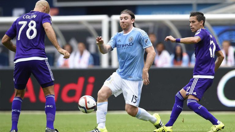 New York City FC midfielder Thomas McNamara (15) attempts to control the ball under pressure from Orlando City FC defender Aurelien Collin (78) in an MLS game at Yankee Stadium on Sunday, July 26, 2015.