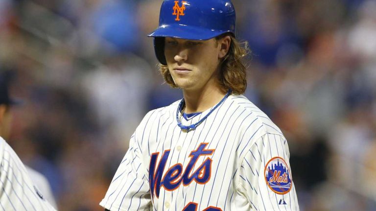 Jacob deGrom of the Mets is congratulated on his third-inning base hit against the Yankees by first base coach Tom Goodwin at Citi Field on Thursday, May 15, 2014.