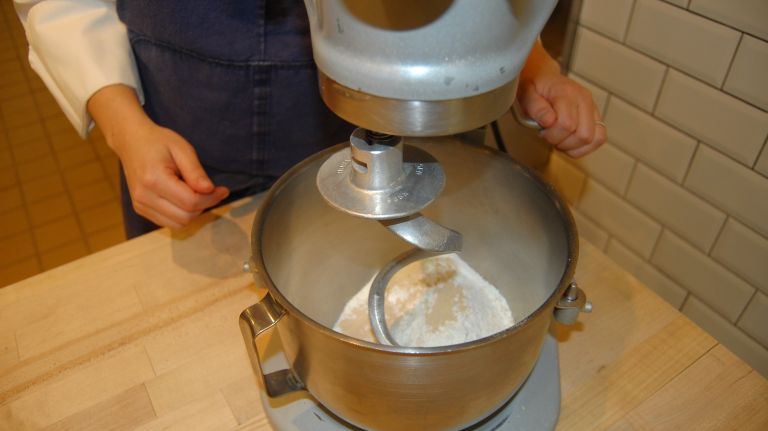 Place the flour and yeast in the bowl of a stand mixer fitted with the dough hook and mix for about 15 seconds to distribute the yeast evenly.