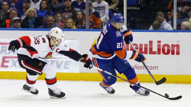 Erik Karlsson of the Ottawa Senators defends against Kyle Okposo of the New York Islanders in the third period at Nassau Coliseum on Friday, March 13, 2015.