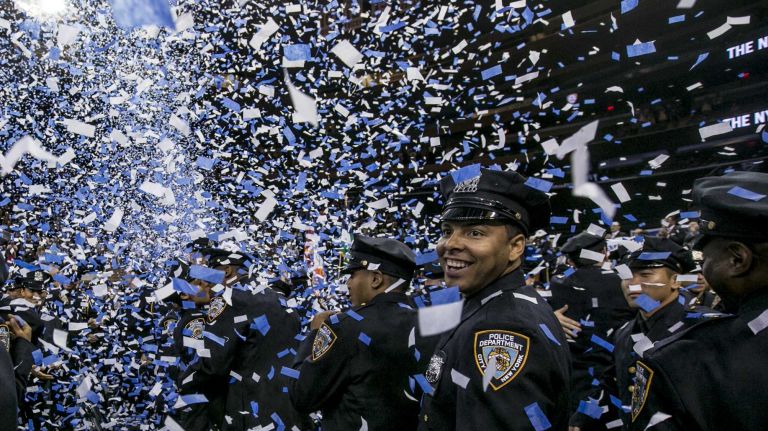 The graduating class celebrates under a hail of confetti at a Police Academy graduation at Madison Square Garden in Manhattan on June 30, 2014.