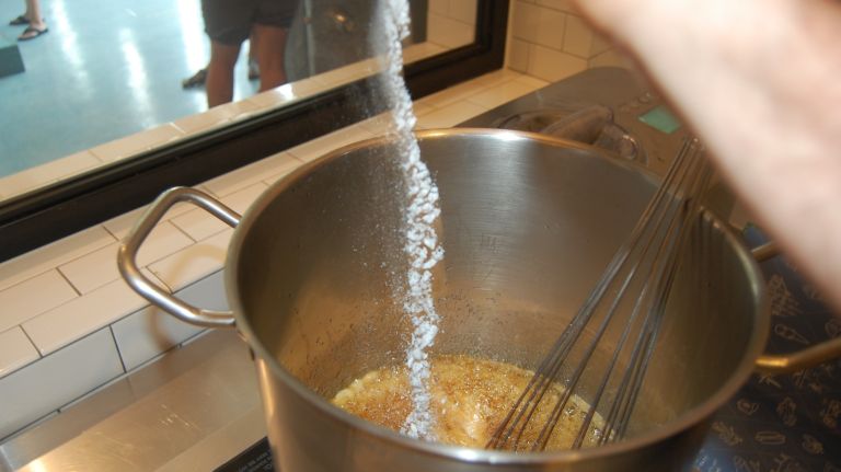 Remove the pan from the heat and, wearing an oven mitt for protection, whisk in 1 tablespoon plus 1 teaspoon baking soda. Whisk vigorously for a few moments to make sure you’ve incorporated all the little bits of baking soda, then stand back and watch the honeycomb grow.