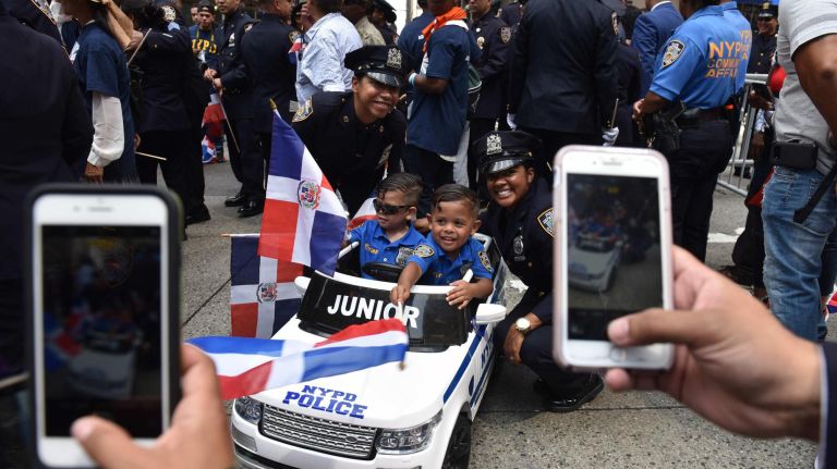 Dominican Day Parade brings color to a cloudy New York City 11 Police officers Karen Rojas and Denisse Caceres take photos of the cutest cops around, 3-year-old twin brothers Evan and Aaron Rolon.