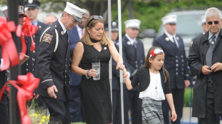 Fallen FDNY firefighter William Tolley's wife, Marie, and daughter, Isabella, leave Chapey and Sons Funeral Home in Bethpage, on April 26, 2017, following his wake services.
