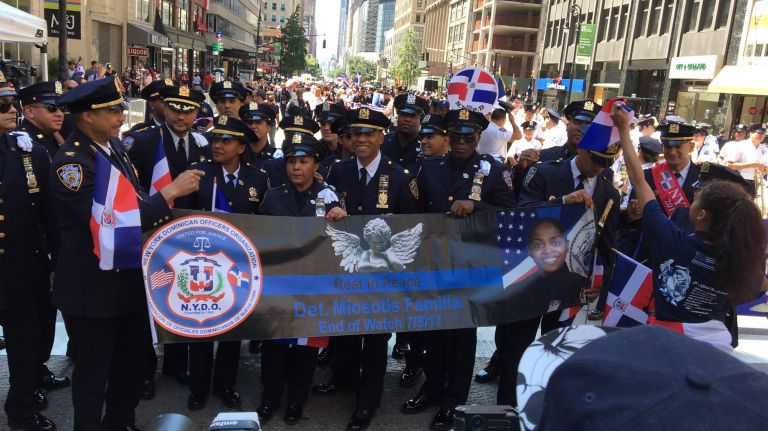 Officers honor slain NYPD Officer Miosotis Familia, who was killed in the line of duty in the Bronx last month, at the start of the Dominican Day Parade on Sunday, Aug. 13, 2017. 