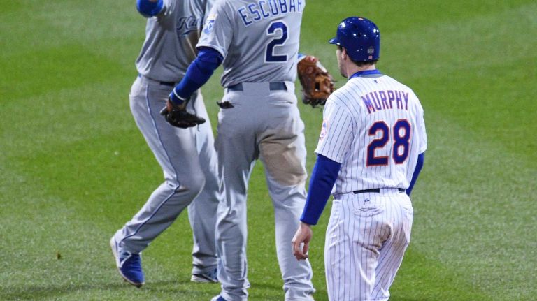 Kansas City Royals shortstop Alcides Escobar and Royals first baseman Eric Hosmer celebrate their 5-3 win as New York Mets second baseman Daniel Murphy walks by in Game 4 of the World Series at Citi Field on Saturday, Oct. 31, 2015.