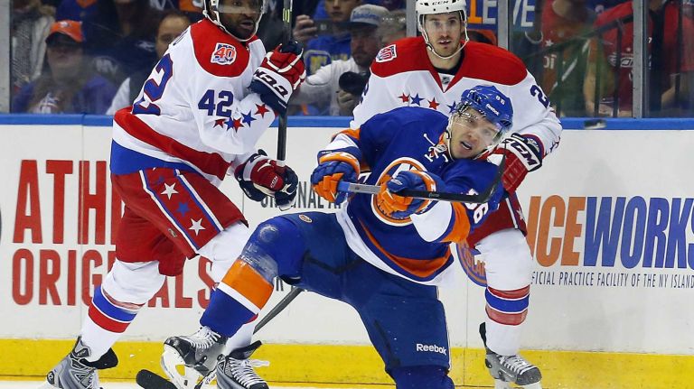 Nikolay Kulemin #86 of the New York Islanders clears the puck during a first-period penalty kill against Joel Ward #42 of the Washington Capitals during Game 3 of the Eastern Conference quarterfinals at Nassau Coliseum on Sunday, April 19, 2015.