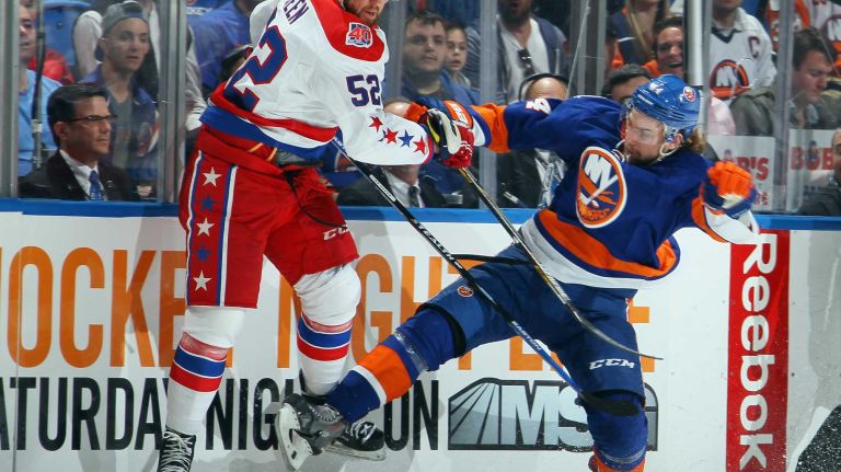 Calvin de Haan #44 of the New York Islanders checks Mike Green #52 of the Washington Capitals during the first period in Game 3 of the Eastern Conference quarterfinals during the 2015 NHL Stanley Cup playoffs at the Nassau Veterans Memorial Coliseum on April 19, 2015.