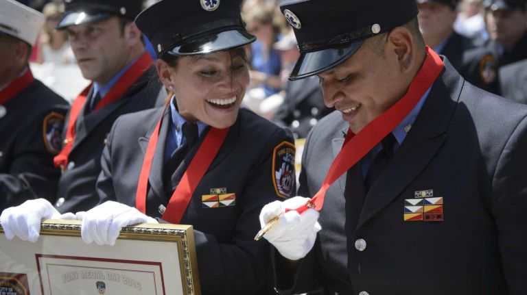 FDNY Paramedic Marilyn Arroyo of Northport, left, and FDNY Paramedic Jimmy Guailacela of Corona, Queens share a laugh after receiving the Paramedic Carlos Lillo/Lieutenant Ricardo Quinn Medal, which was awarded for the first time during the FDNY Medal Day Ceremony in front of City Hall in Manhattan on Wednesday, June 01, 2016. Paramedics Arroyo and Guailacela rescued three people from a submerged car in Queens in 2012.