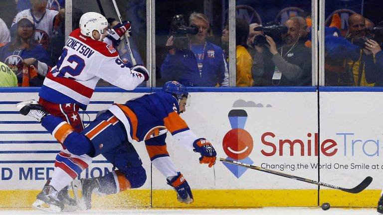 Evgeny Kuznetsov #92 of the Washington Capitals checks Nick Leddy #2 of the New York Islanders in the first period during Game 3 of the Eastern Conference quarterfinals at Nassau Coliseum on Sunday, April 19, 2015.