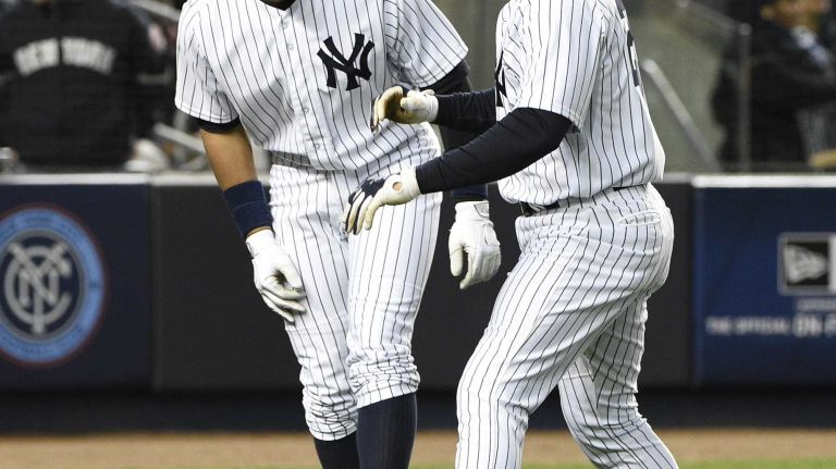 New York Yankees designated hitter Alex Rodriguez and New York Yankees first baseman Mark Teixeira celebrate after Teixeira's two-run home run in the third inning against the New York Mets in a baseball game at Yankee Stadium on Friday, April 24, 2015.