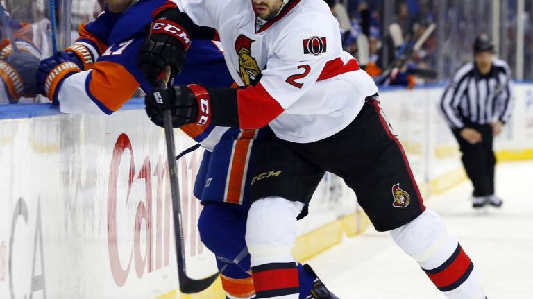 Jared Cowen of the Ottawa Senators checks Matt Martin of the New York Islanders in the first period at Nassau Coliseum on Friday, March 13, 2015.