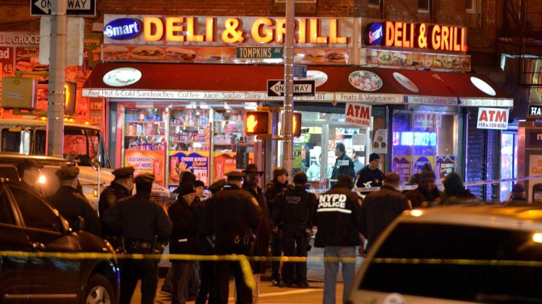 Investigators work in the area where two NYPD officers were shot and killed in the Bedford-Stuyvesant neighborhood of Brooklyn on Saturday, Dec. 20, 2014.