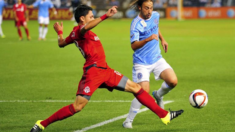 New York City FC midfielder Ned Grabavoy is pursued by Toronto FC midfielder Marco Delgado in an MLS game at Yankee Stadium on Wednesday, Sept. 16, 2015.