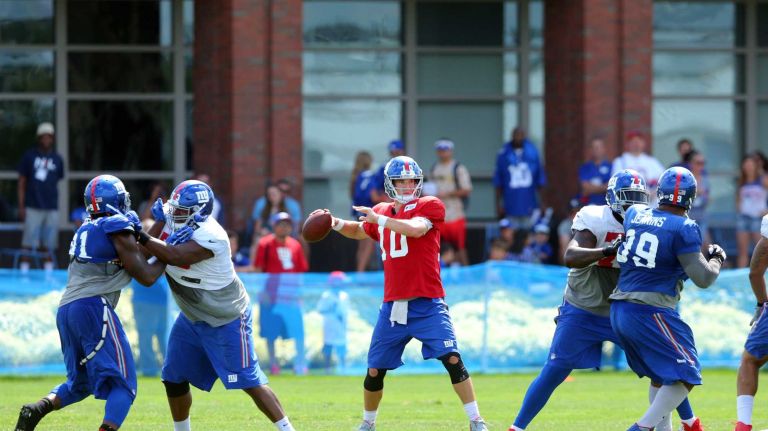 New York Giants quarterback Eli Manning #10 drops back to pass during training camp at the Quest Diagnostics Training Center in East Rutherford, N.J., on Sunday, Aug. 2, 2015.