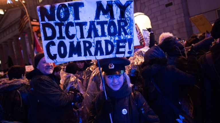 Madeleine Bolle, 18, holds a protest sign at a rally and march from Foley Square to the Trump Building at 40 Wall St. in Manhattan on Jan. 20, 2017.
