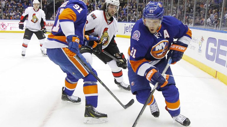 Kyle Okposo and John Tavares of the New York Islanders control the puck in the first period against Jared Cowen of the Ottawa Senators at Nassau Coliseum on Friday, March 13, 2015.