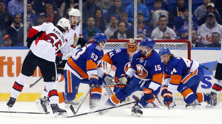 Casey Cizikas, left, Jaroslav Halak and Cal Clutterbuck of the New York Islanders defend a first period shot against Erik Karlsson of the Ottawa Senators at Nassau Coliseum on Friday, March 13, 2015.