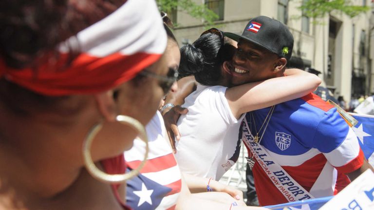 Victor Cruz of the New York Giants receives a hug from a reveler during the 57th annual National Puerto Rican Day Parade in Manhattan on Sunday, June 8, 2014.