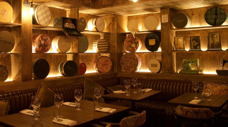 The intimate dining space is decorated with vintage ladies' hat boxes, bearing brand names like Saks Fifth Avenue. 