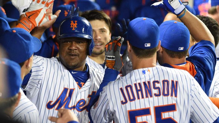 New York Mets second baseman Juan Uribe and catcher Travis d'Arnaud are greeted in the dugout after they score on the two-run home run by d'Arnaud against the Miami Marlins during the sixth inning of a game at Citi Field on Monday, Sept. 14, 2015.