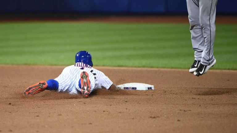 New York Mets pinch runner Eric Young Jr. steals second base as Miami Marlins third baseman Miguel Rojas leaps for the throw during the seventh inning of a baseball game at Citi Field on Monday, Sept. 14, 2015.