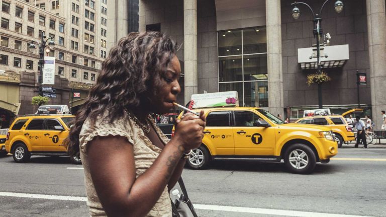 Decrease in anti-tobacco budget linked to increase in smoking rate: report 1 A woman lights a cigarette in New York City.